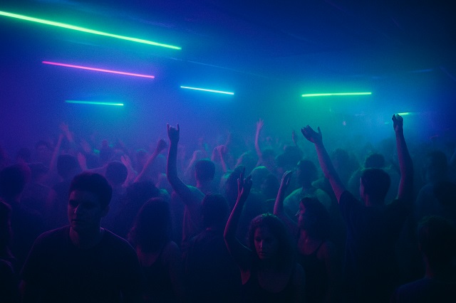 Underground rave crowd dancing under neon lights