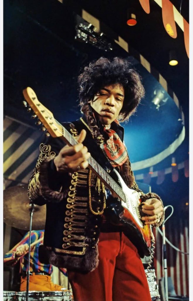 Jimi Hendrix performing on stage with electric guitar