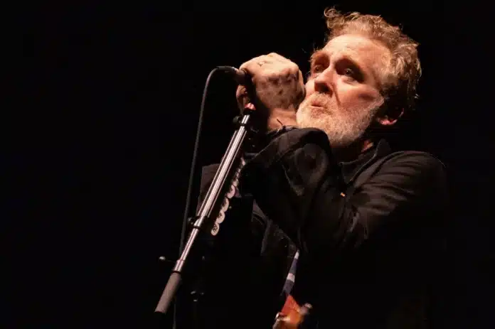 Glen Hansard performing live with acoustic guitar on stage in Dublin