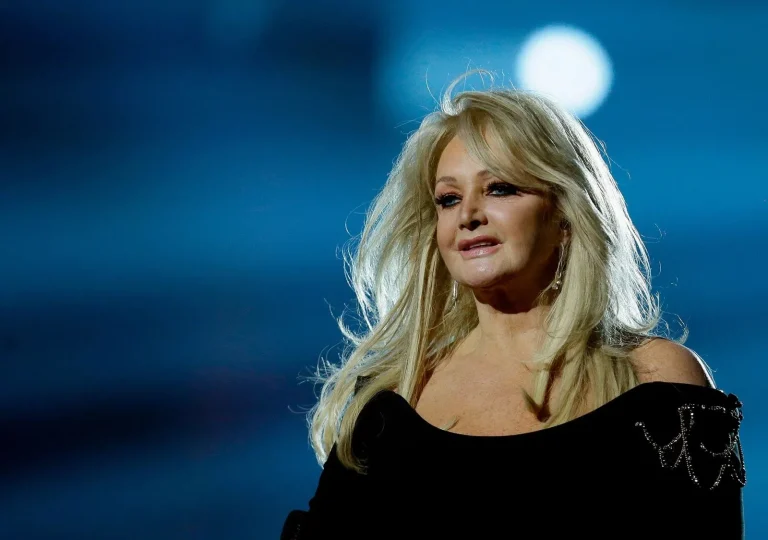 Bonnie Tyler performing live on stage in the 1980s, holding a microphone